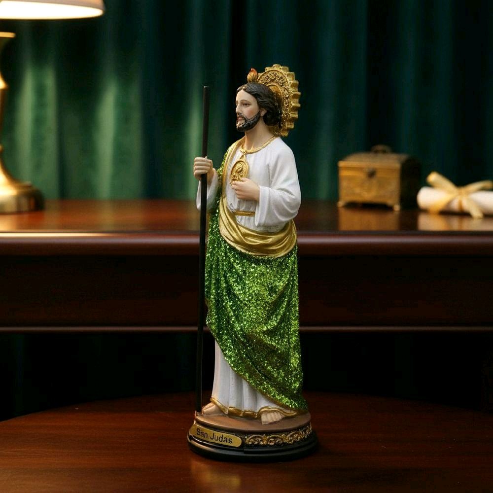 Estatua de San Judas Tadeo con manto verde en un altar de luz cálida